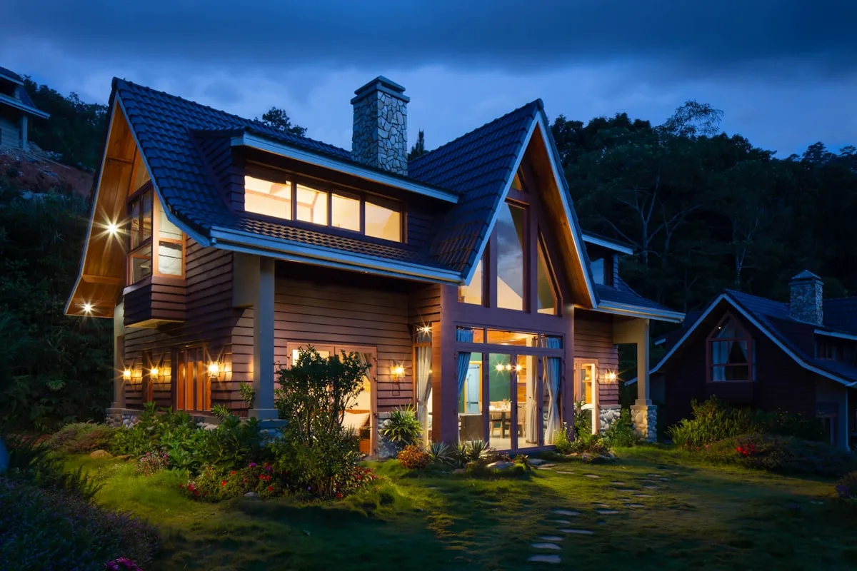 A warmly lit home under a new roof at night